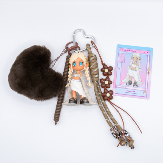 Silver heart keychain featuring Lil Peach Riot Poppy Valkyrie from the Loading series with matching charms including a beige lanyard with beads, brown flower charms, a faux fur heart and a plastic twisting lanyard next to its card