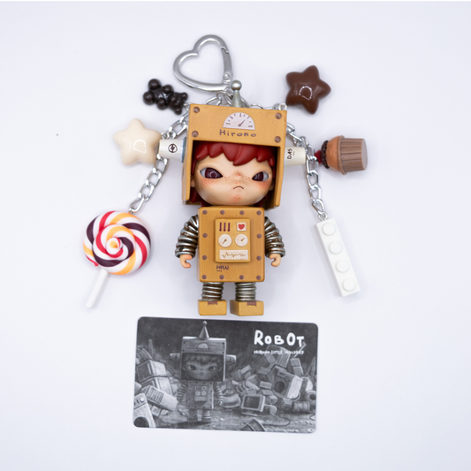 Silver heart keychain with Hirono Robot figure from POP MART's Little Mischief series and matching charms including a lollipop, stars, gummy bear, cupcake, and lego piece next to its card.
