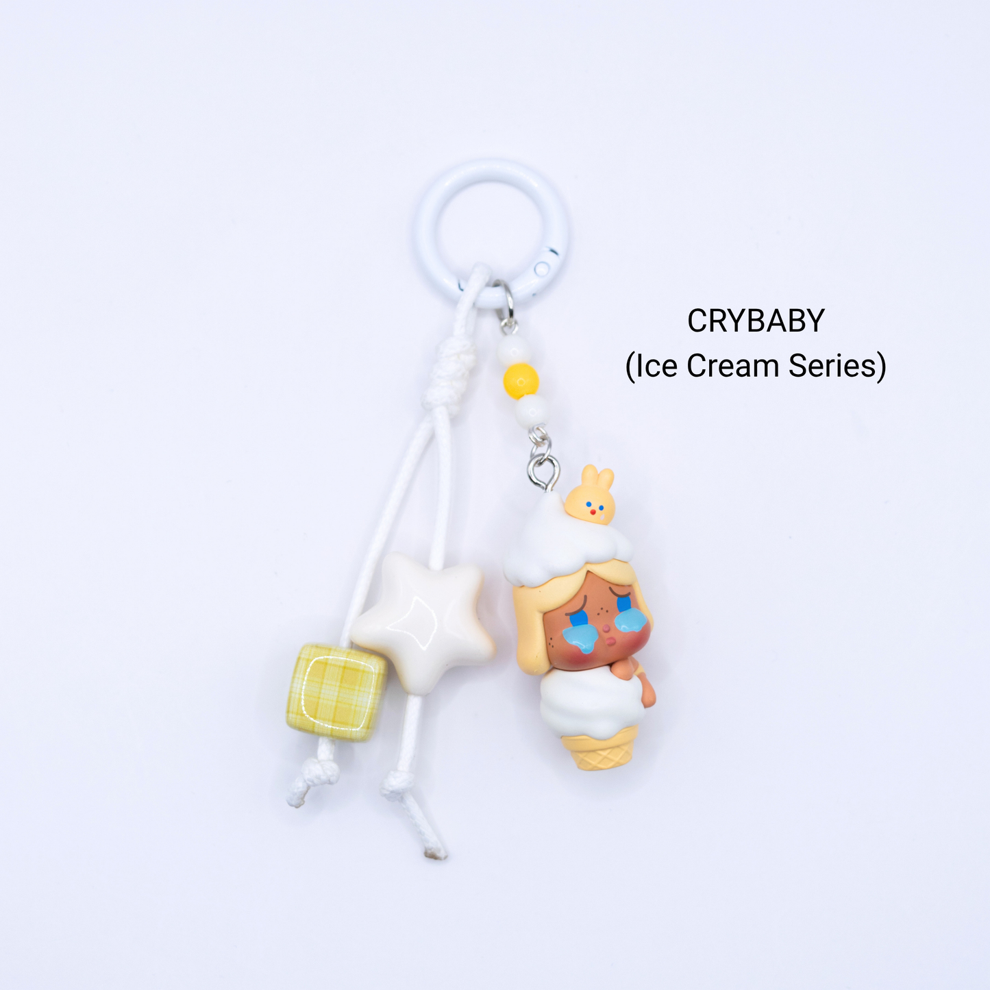 White keychain with Crybaby pop bean from the Ice Cream Series with matching star and dice charms