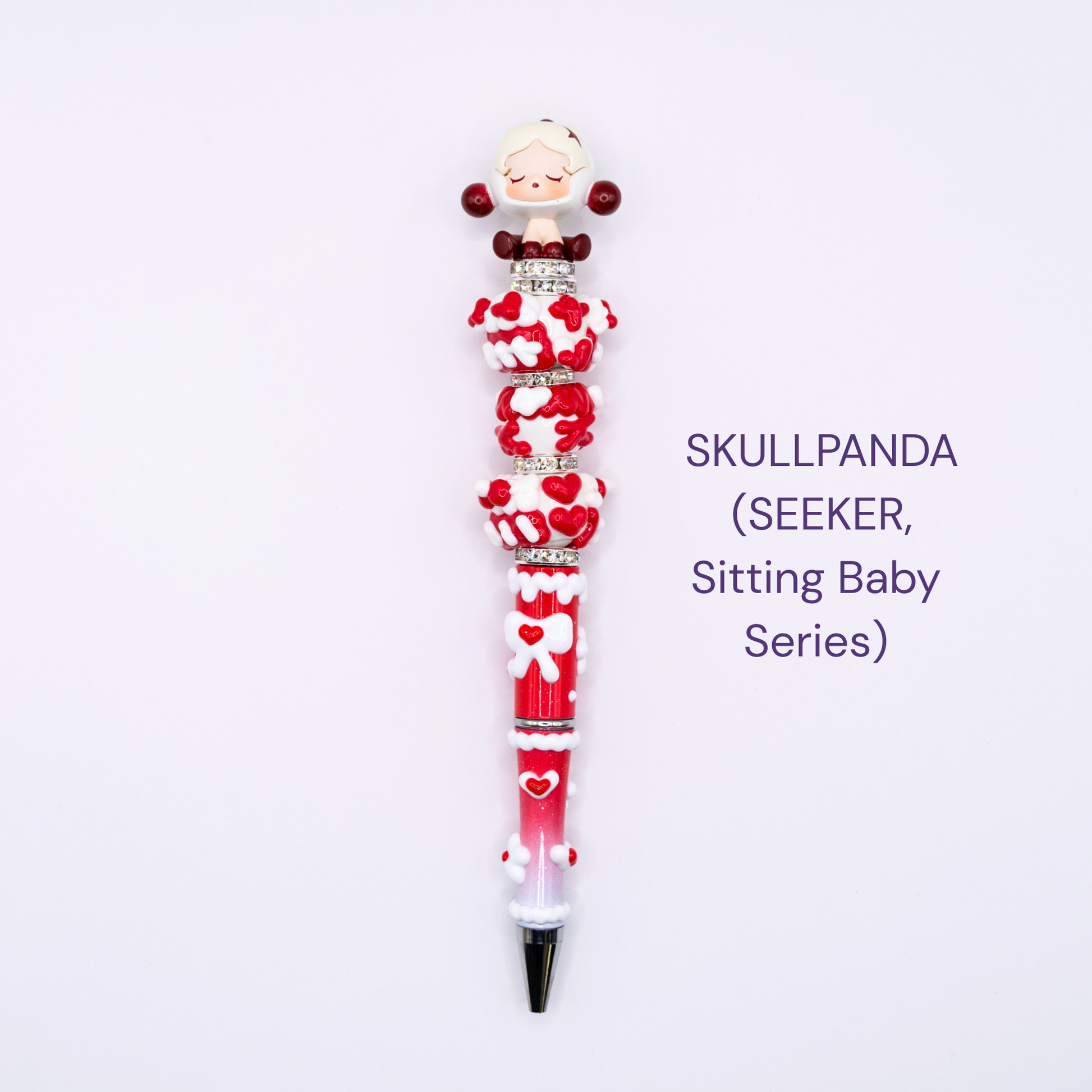 Colorful beaded pen with cartoon character design on a white background, labeled 'SKULLPANDA (SEEKER, Sitting Baby series)'.