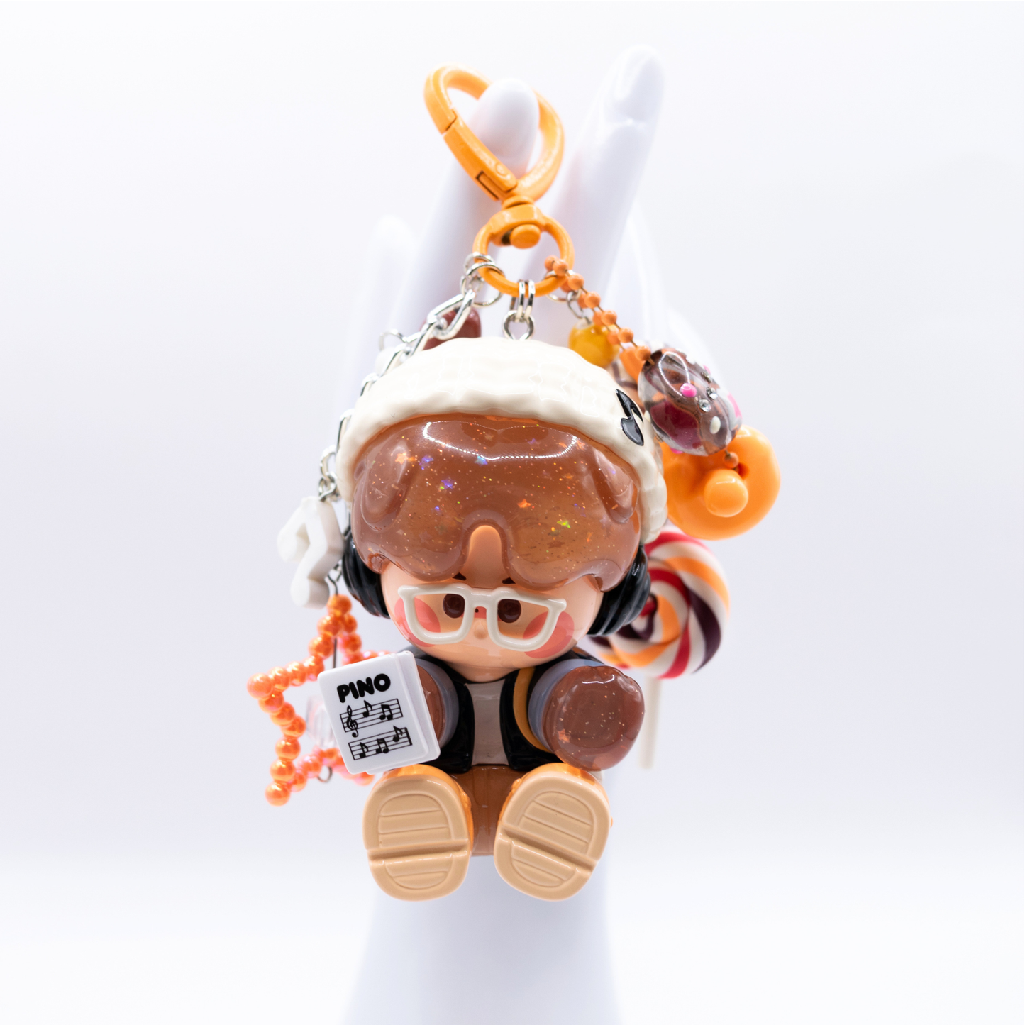 Orange heart keychain with Pino Jelly SStudio figure from Pop Mart's Star Project Series with matching charms including lollipop, star, notes, heart).