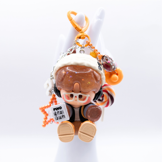 Orange heart keychain with Pino Jelly SStudio figure from Pop Mart's Star Project Series with matching charms including lollipop, star, notes, heart).