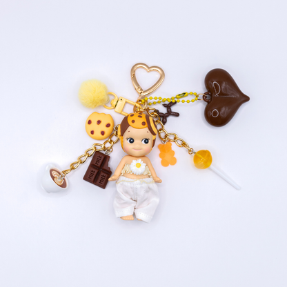 Golden heart keychain featuring Cookie Sonny angel figure with matching charms on a white background