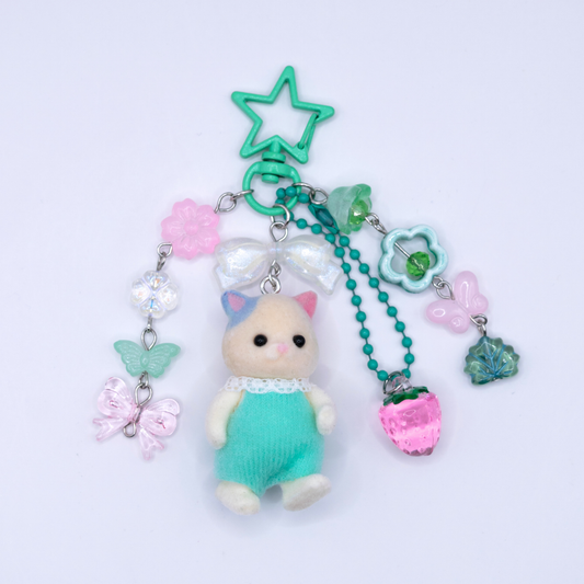 Sylvanian family CAT with mint color overalls and matching flower, butterfly, and strawberry acrylic charms in mint, pink and clear color