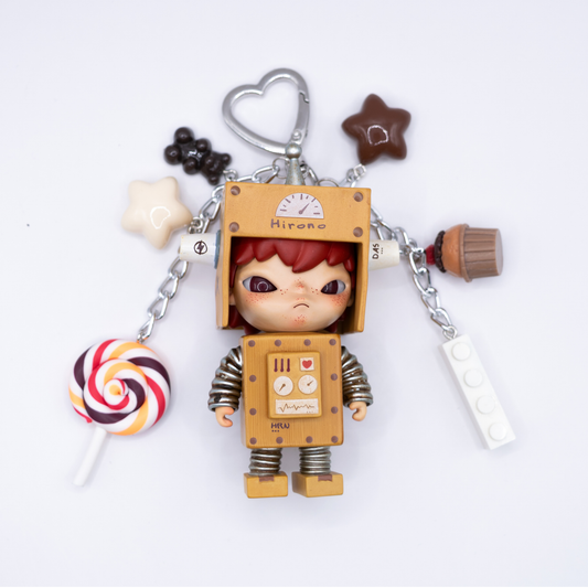Silver heart keychain with Hirono Robot figure from POP MART's Little Mischief series and matching charms including a lollipop, stars, gummy bear, cupcake, and lego piece.