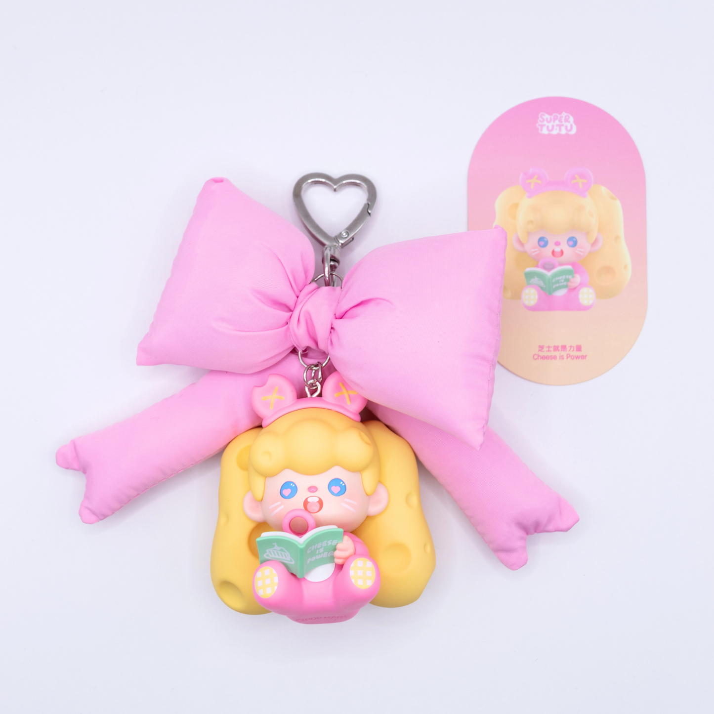 Heart keychain featuring Supertutu figure from Pop Mart's HAPPY-ING! Series and a pink bow with its character card on the side