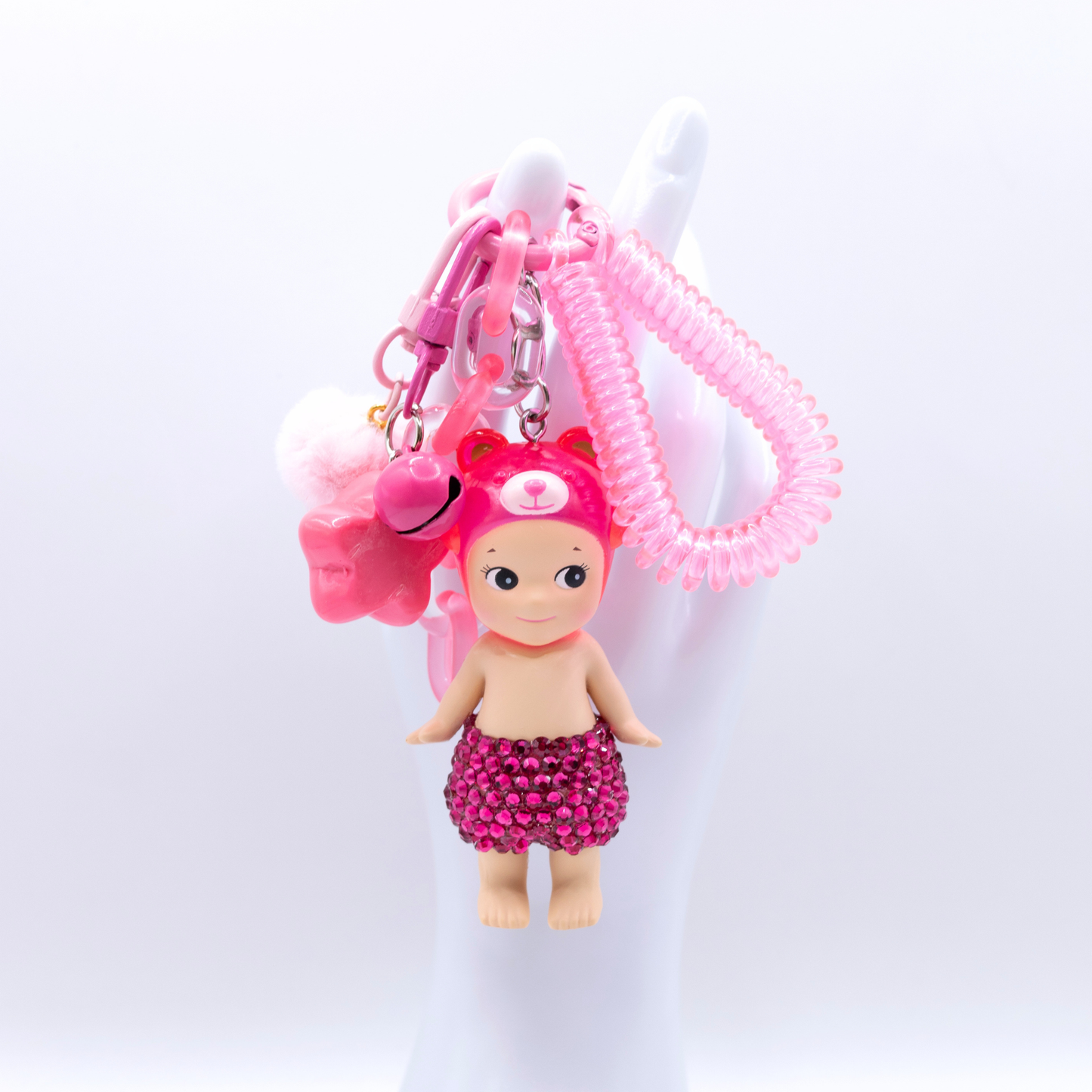 Pink Peach Bear Sonny Angel fiigure with added rhinestones on a pink kreychain with matching charm