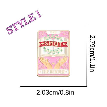 Pink enamel pin with 'Smut' and 'The Reader' text, dimensions shown on a white background.