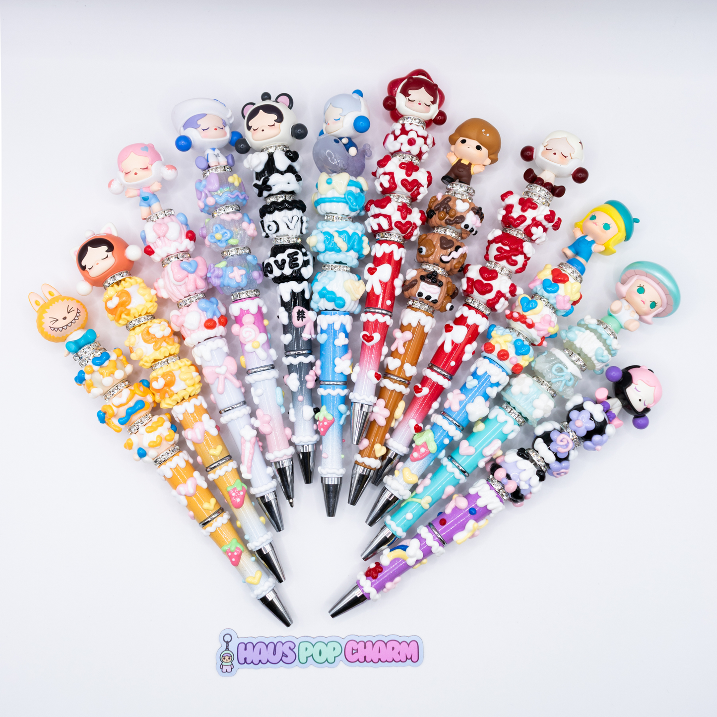 Collection of colorful beaded pens pens with pop beans  on a white background, branded 'Haus Pop Charm'.