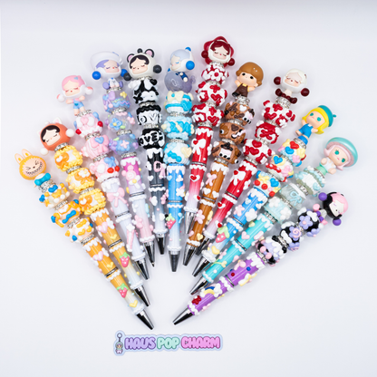 Collection of colorful beaded pens pens with pop beans  on a white background, branded 'Haus Pop Charm'.