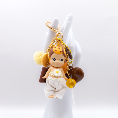 Golden heart keychain featuring Cookie Sonny angel figure with matching charms on a white background