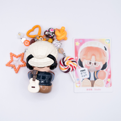 Orange heart keychain with Pino Jelly SStudio figure from Pop Mart's Star Project Series with matching charms including lollipop, star, notes, heart) from the back next to its card