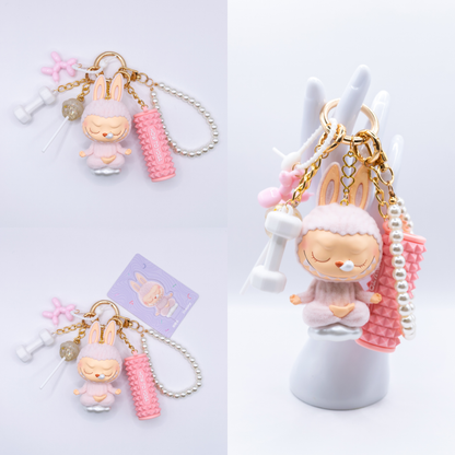 Golden Keychain with Labubu Lazy Yoga Figure and matching charms from three different angles on a white background