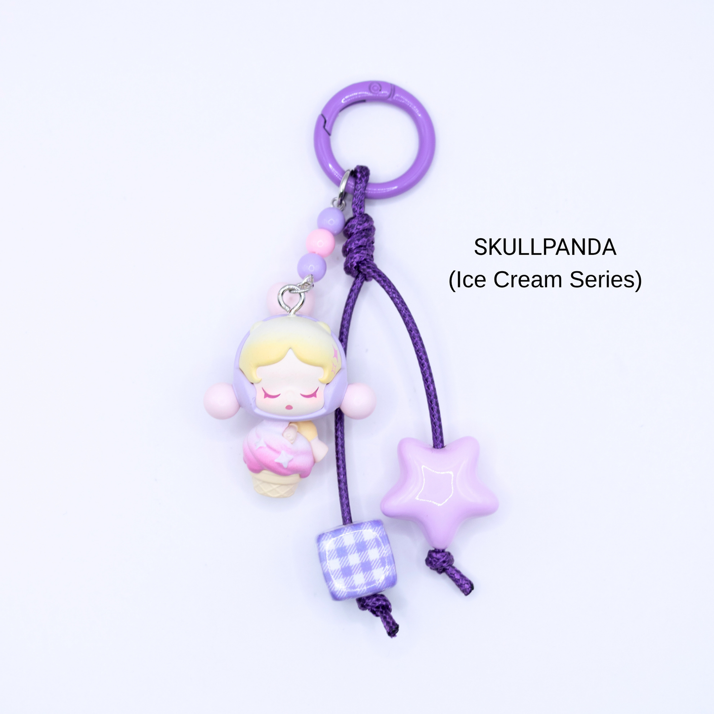 Purple keychain with Skullpanda pop bean from the Ice Cream Series with matching star and dice charms