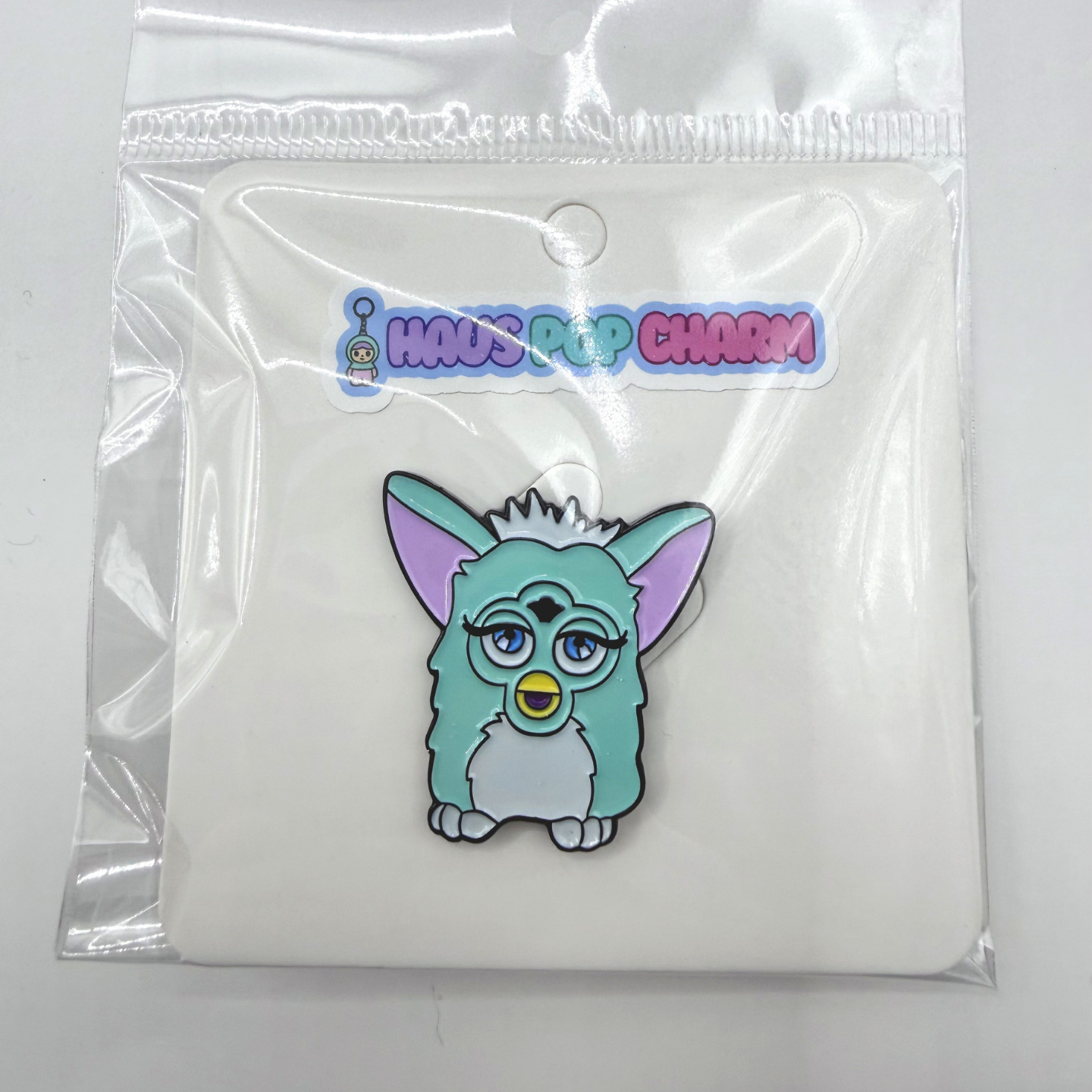 Cartoon character charm in a clear plastic packaging with 'Haus Pop Charm' branding.