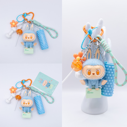 Orange Keychain with Labubu Lazy Yoga Show Off Figure and matching charms from three different angles on a white background