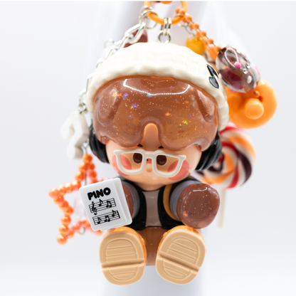Orange heart keychain with Pino Jelly SStudio figure from Pop Mart's Star Project Series with matching charms including lollipop, star, notes, heart).