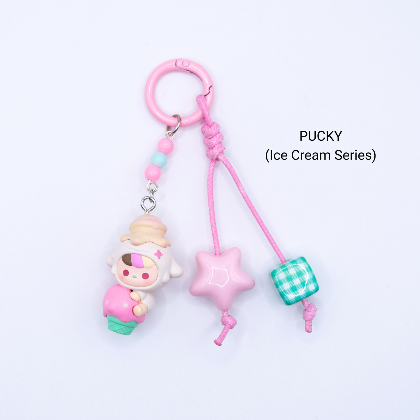 Pink keychain with Pucky pop bean from the Ice Cream Series with matching star and dice charms