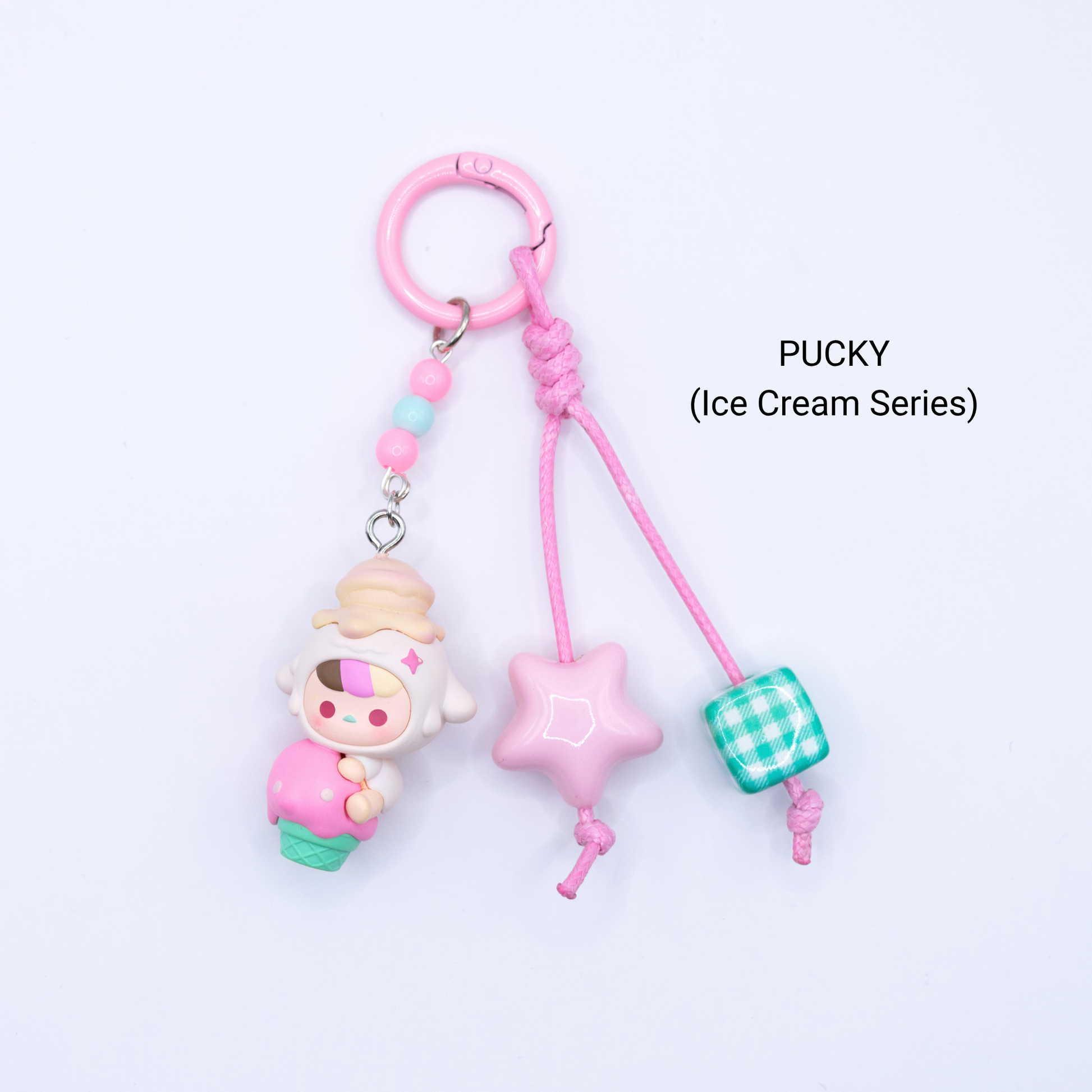 Pink keychain with Pucky pop bean from the Ice Cream Series with matching star and dice charms