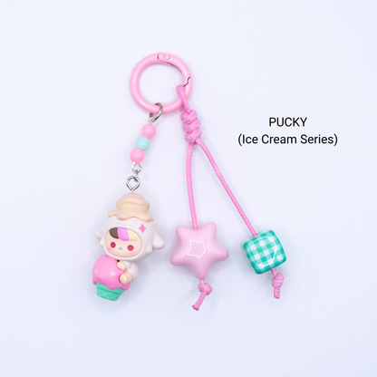 Pink keychain with Pucky pop bean from the Ice Cream Series with matching star and dice charms