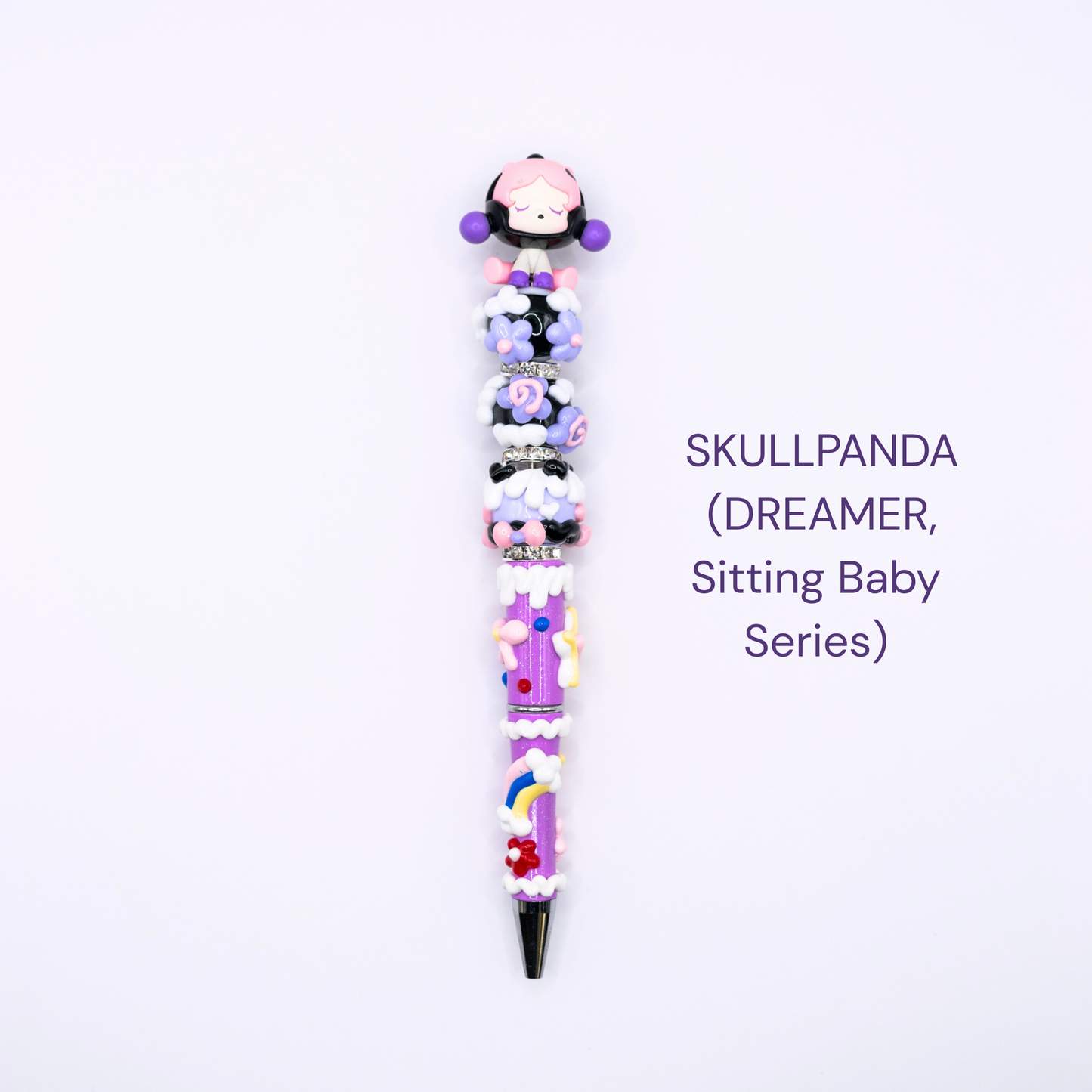 Colorful beaded pen with cartoon character design on a white background, labeled 'SKULLPANDA DREAMER Sitting Baby Series'.