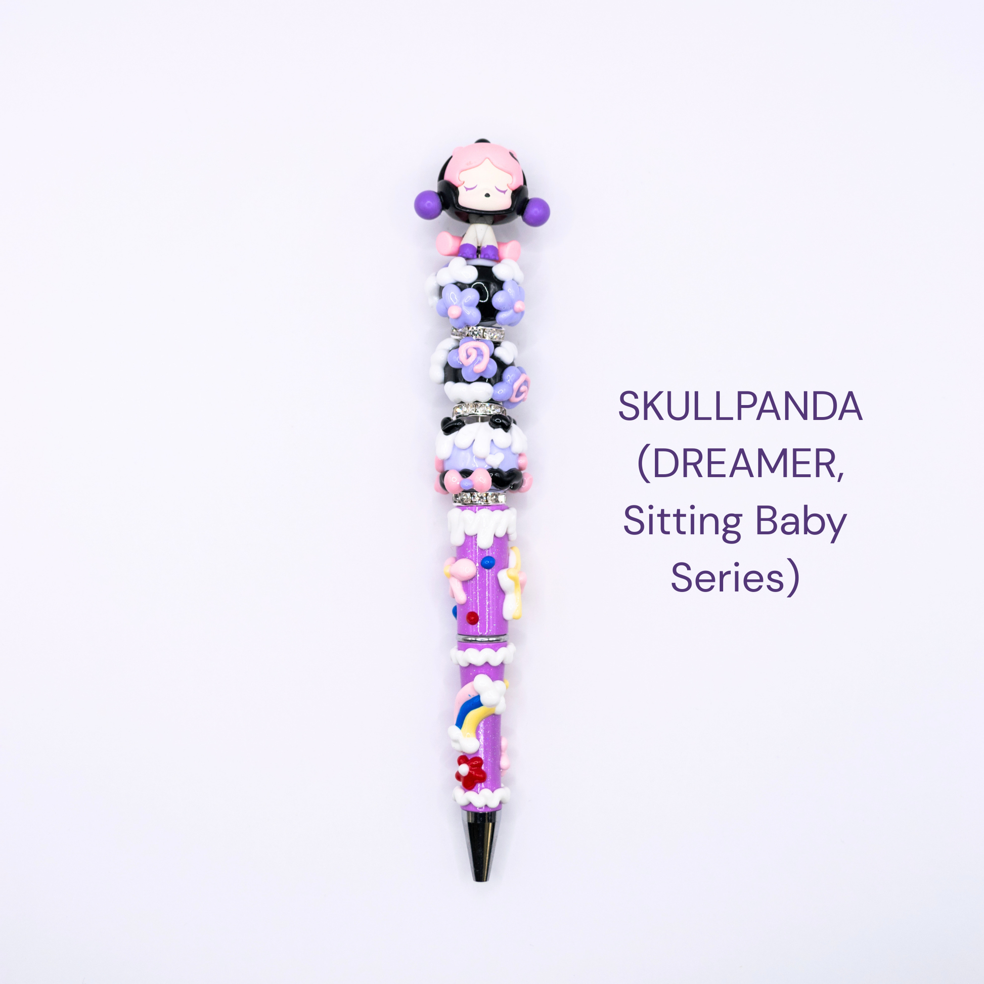 Colorful beaded pen with cartoon character design on a white background, labeled 'SKULLPANDA DREAMER Sitting Baby Series'.