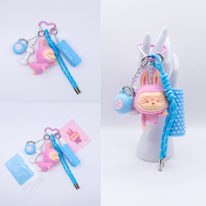 Pink Keychain with Labubu Lazy Yoga Sweating Figure and matching charms from three different angles on a white background
