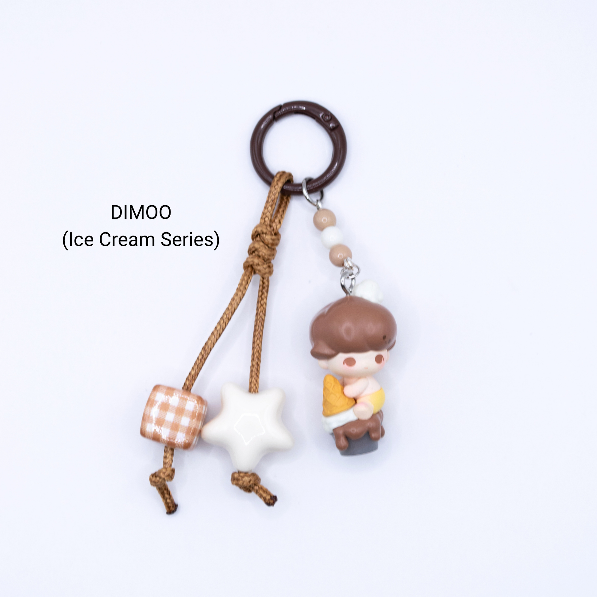 Brown keychain with Dimoo pop bean from the Ice Cream Series with matching star and dice charms